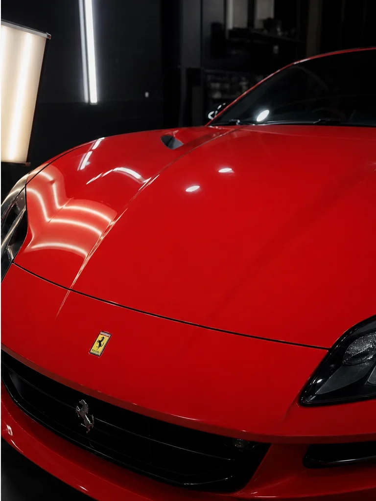 Red Ferrari hood after hail damage repair
